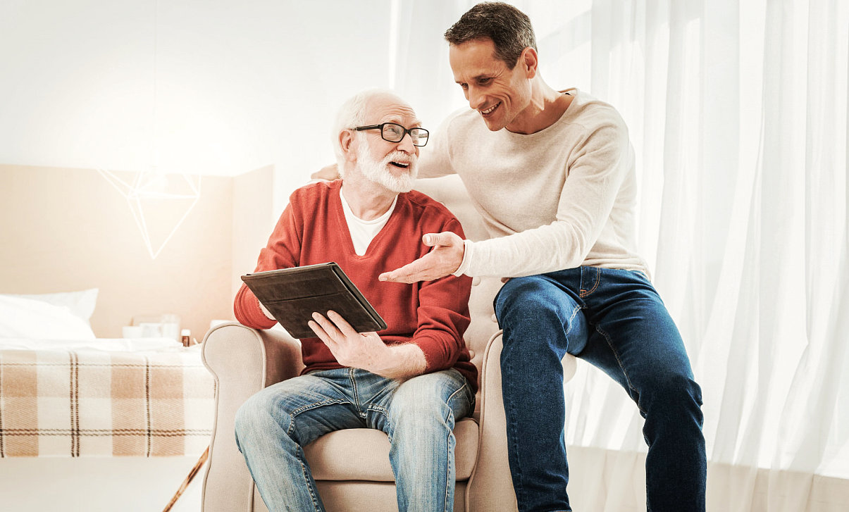 caregiver and old man happily talking