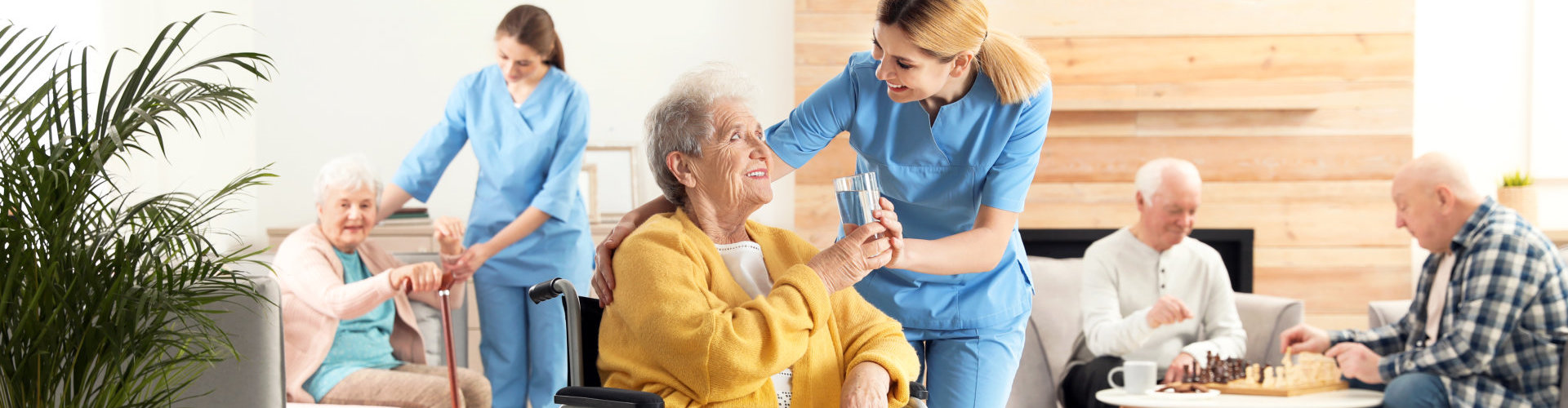 caregiver giving water to old woman